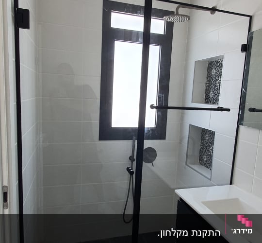 מקלחון זכוכית עם ראש מקלחת עגול וקיר אריחים